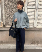 Marque Johanna Paris, blouson court gris resserré dans le bas, détails velours marine, chaud et élégant.