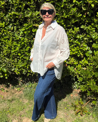 chemise coupe loose blanche avec broderies et sequins au niveau des manches, pate de boutonnage. Convient pour une taille 44 au 48