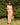 robe longue d'été imprimée tropicale, dos croisé et bretelles fines, coupe fluide bohème dans un jardin ensoleillé