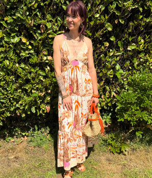 robe longue d'été imprimée tropicale, dos croisé et bretelles fines, coupe fluide bohème dans un jardin ensoleillé