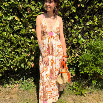 robe longue d'été imprimée tropicale, dos croisé et bretelles fines, coupe fluide bohème dans un jardin ensoleillé