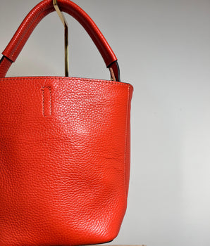 sac bourse en cuir couleur orange peut se porter à la main ou en bandoulière